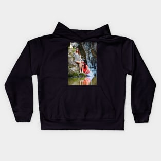 Two beautiful young women leaning on rocks beside a river Kids Hoodie